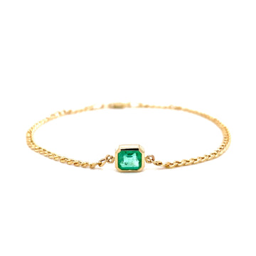 Gold-tone bracelet with square green gemstone bezel and chain links, flat lay