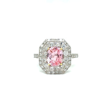 Platinum ring with pink oval sapphire center and diamond halo, split shoulders