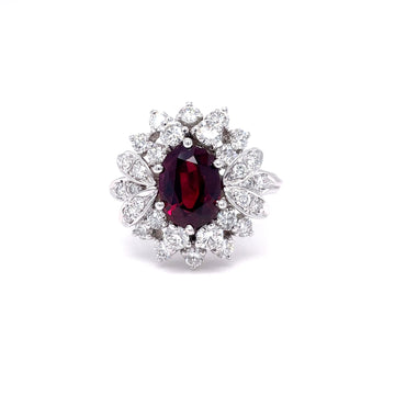 Platinum ring with oval heated ruby center and diamond halo cluster