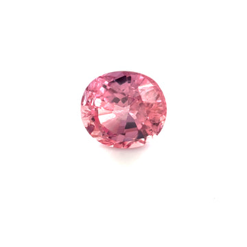 Faceted oval pink sapphire gemstone on white background