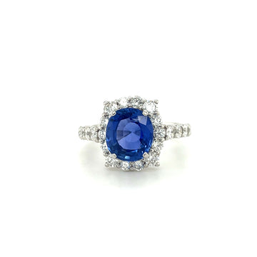 Platinum sapphire and diamond halo ring with a blue oval center stone.