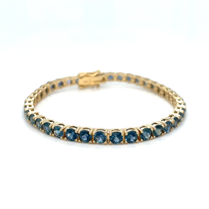 Gold-toned tennis bracelet with blue round sapphire stones in repeating rows
