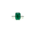 Square green emerald centerpiece with diamond halo and slim pave band