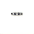 Silver-tone eternity ring with square-cut diamonds and dark blue stones across top.