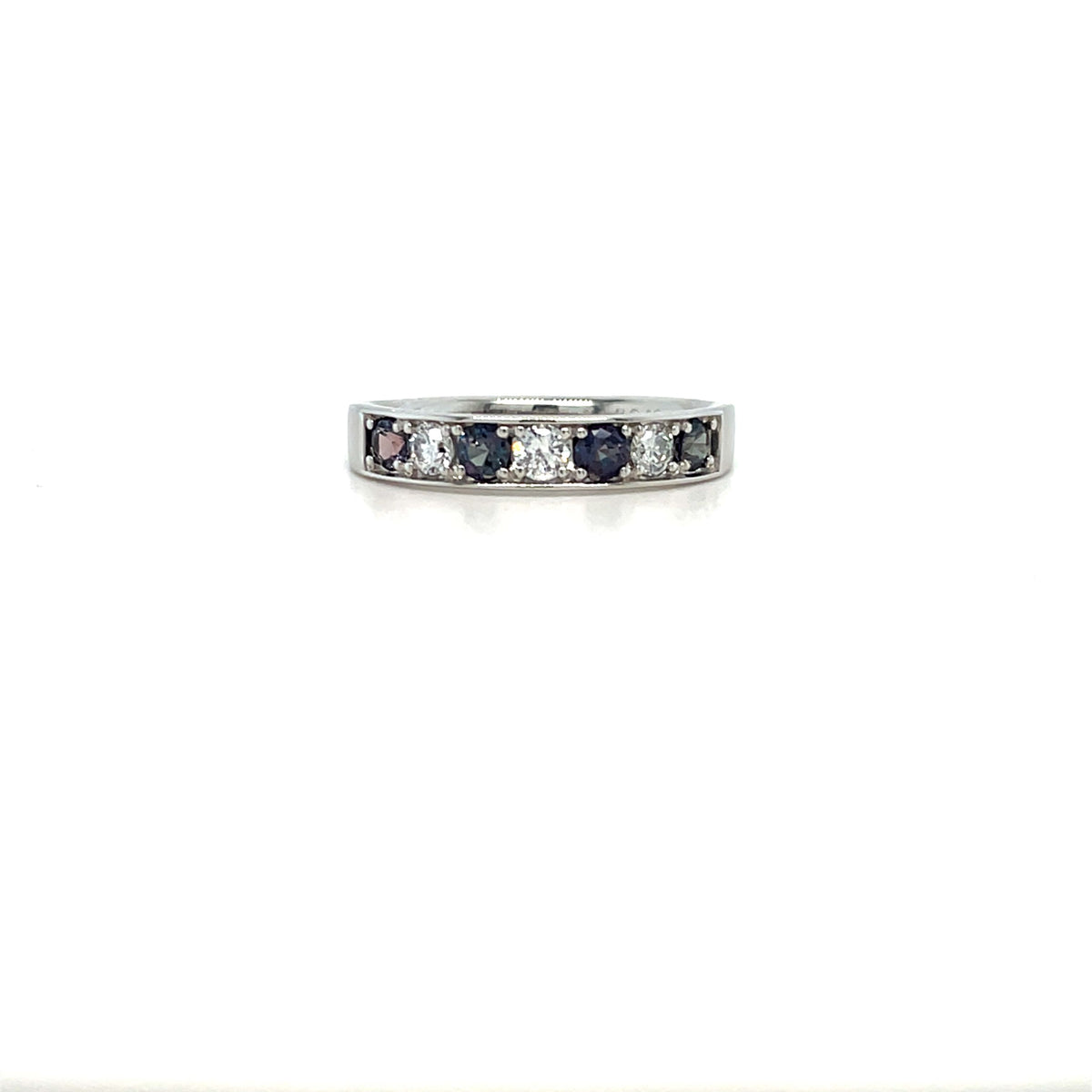 Silver-tone eternity ring with square-cut diamonds and dark blue stones across top.