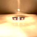Rose-gold tone ring with inset stones and diamond accents along the band.
