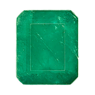 Green emerald gemstone, square cushion cut with visible facets and dark inclusions.