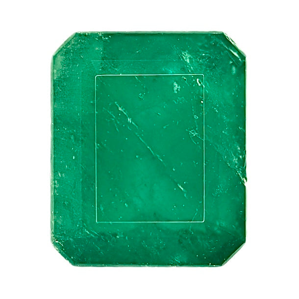 Green emerald gemstone, square cushion cut with visible facets and dark inclusions.