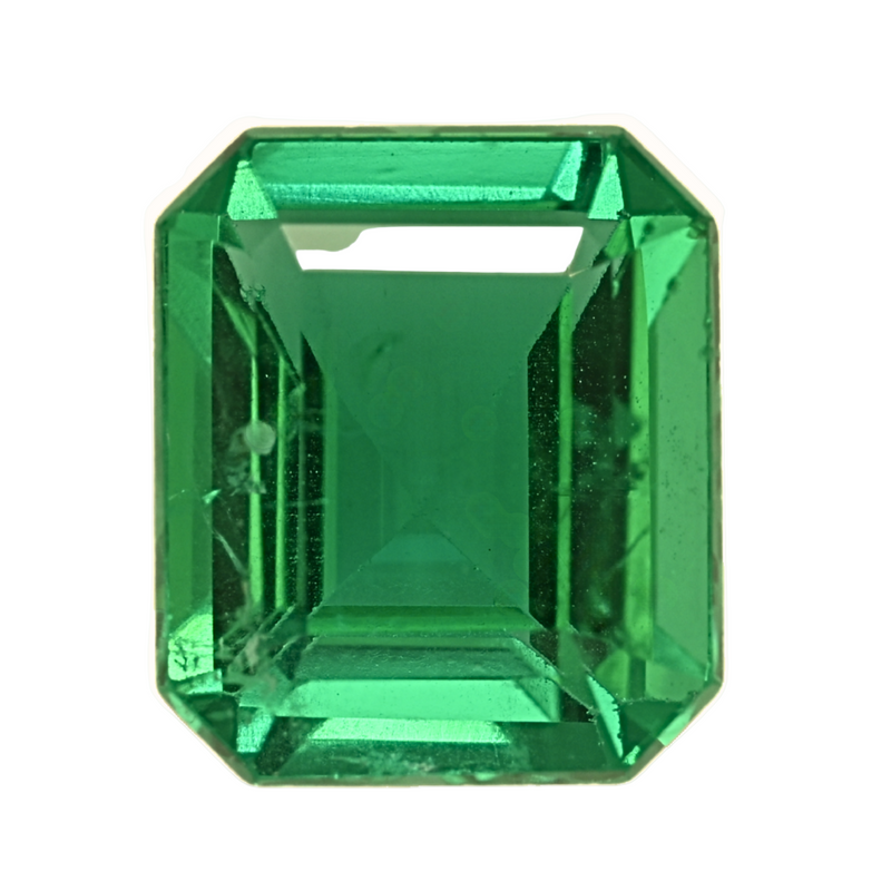 Emerald gemstone close-up, emerald-cut vivid green with crisp facet edges