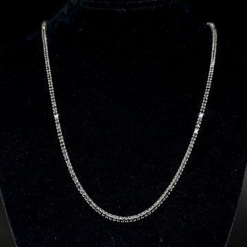 Diamond tennis necklace with continuous row of round stones and V-shaped drape, white metal.