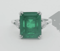 Silver ring with emerald-green square center stone and halo prongs